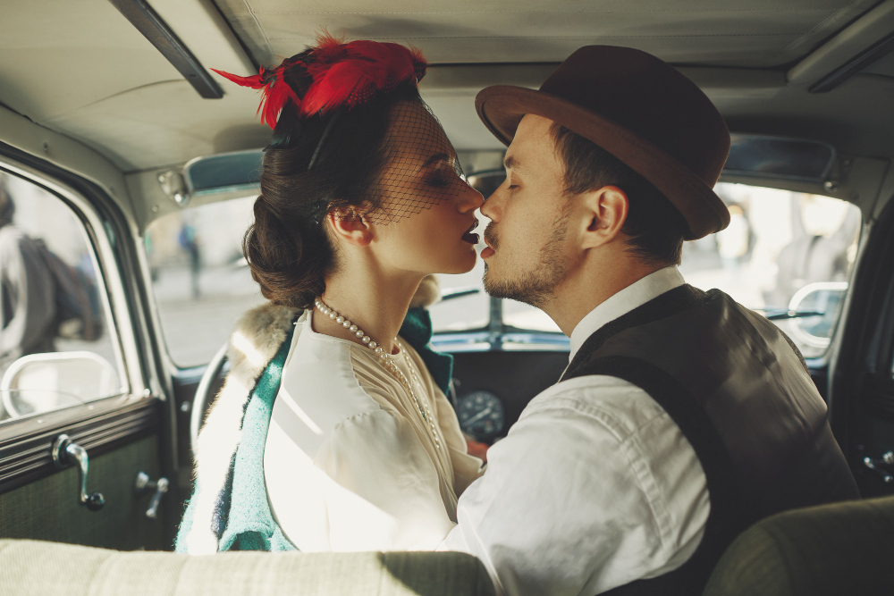 Couple leaning close together in a vintage car