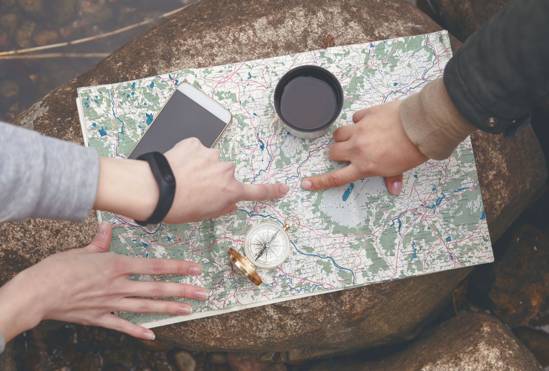 Hands pointing to a location on a map for finding local pilots