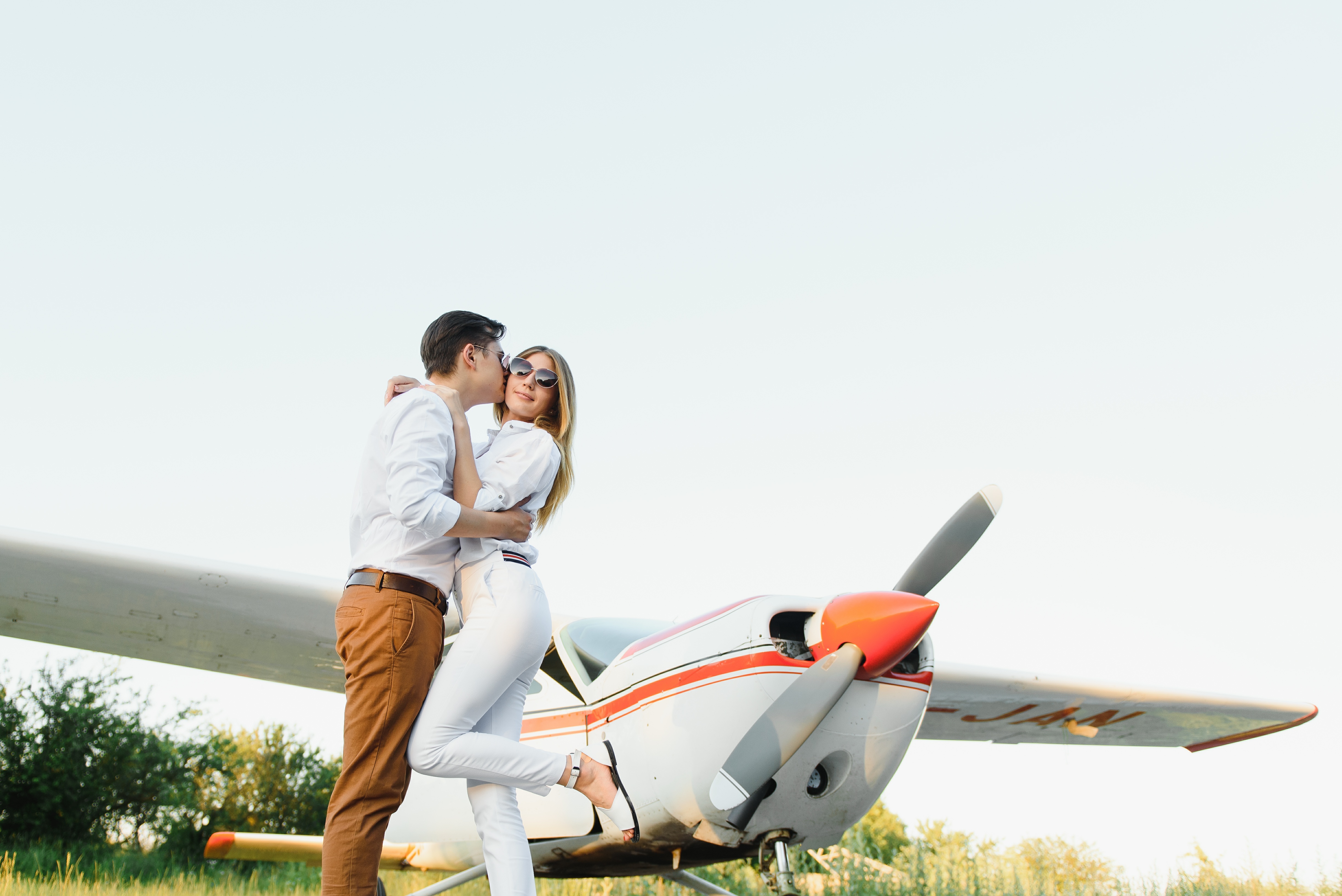 Romantic pilot dating couple beside airplane